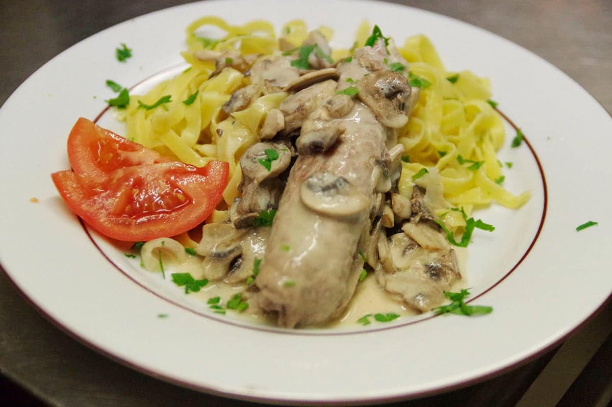 Tagliatelles et escalope nappées d’une sauce crémeuse aux champignons.
